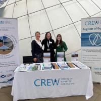 CREW stand with three staff at conference